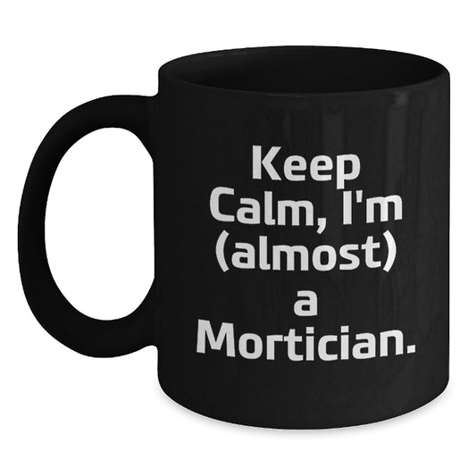 Mortician Humor Gifts from Friends for Men, 'Keep Calm, I'm (almost) A Mortician.' Black Coffee Mug, Graduation Unique Gifts - Main